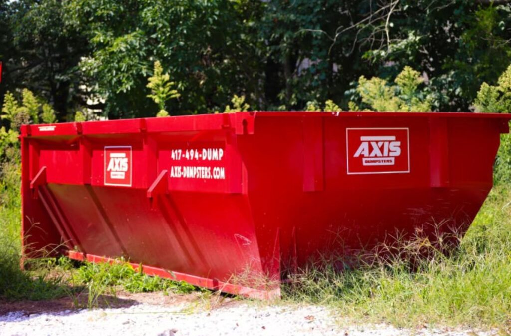 Axis Dumpsters employee delivering a construction dumpster for rental in Springfield, MO. Reliable and fast service for local projects.