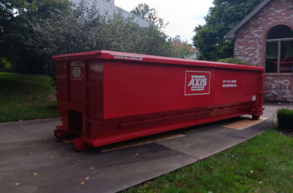 An Axis Dumpsters truck delivering a roll off dumpster in Kimberling City, MO, ensuring fast and reliable waste management services.