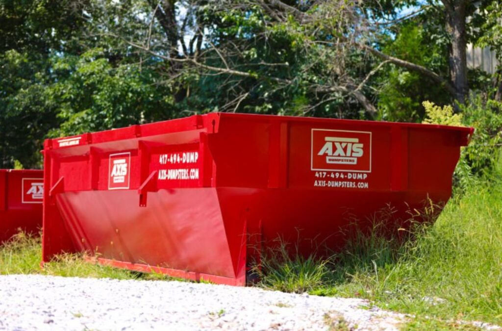 A Axis Dumpsters staff member placing a roll-off dumpster at a home in Ozark, MO, highlighting its usefulness for roofing waste removal.