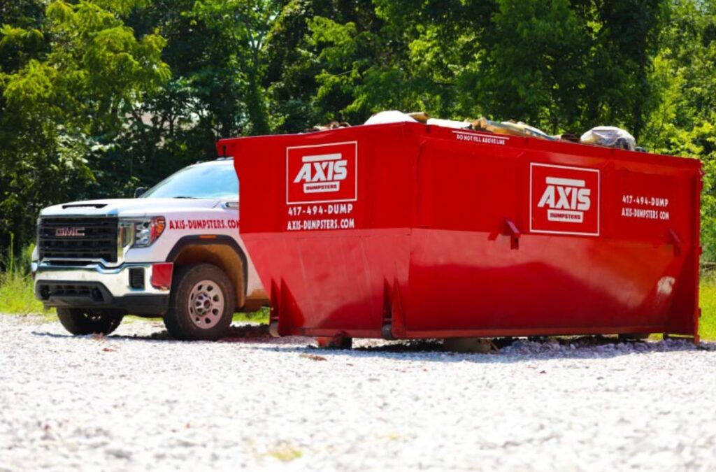 A Axis Dumpsters employee assisting with a roofing dumpster rental in Ozark, MO, ensuring efficient cleanup during an active tear-off.