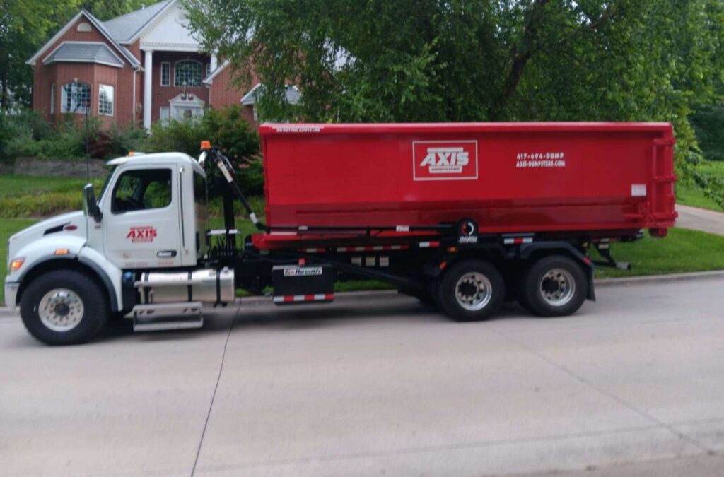 A Axis Dumpsters expert placing a heavy-duty container in Nixa, MO, illustrating why local contractors prefer our roofing dumpster services. Roofing Dumpster Rental near me.